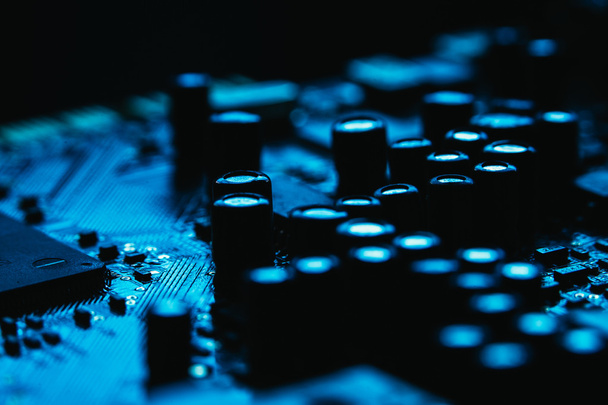 Computer motherboard closeup blue color on dark background - Fotó, kép