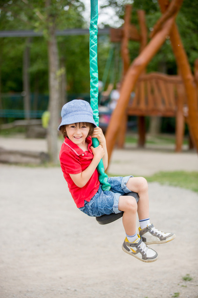 Cute child, boy, rides on Flying Fox play equipment in a childre - Foto, Imagem