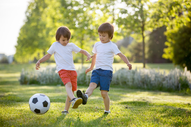 Two cute little kids, playing football together, summertime. Chi - Φωτογραφία, εικόνα