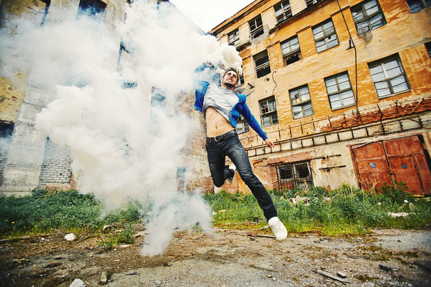 Jonge man loopt met rook - Foto, afbeelding