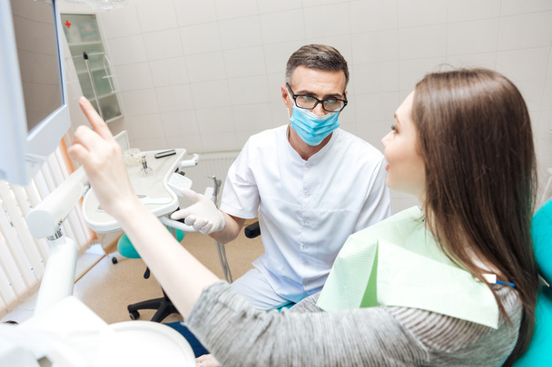 Dentista masculino mostrando mulher sua boca raio-x no computador
 - Foto, Imagem