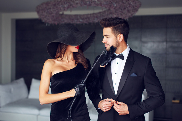 Femme sensuelle en chapeau noir et fouet avec amant
 - Photo, image