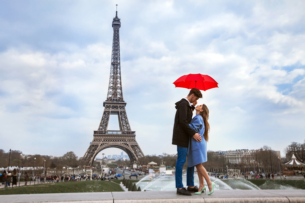 couple with umbrella near Eiffel Tower - Fotoğraf, Görsel