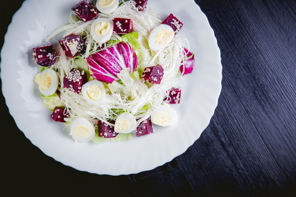Buriak salad, greens and perepelin?h eggs, sesame - Фото, изображение
