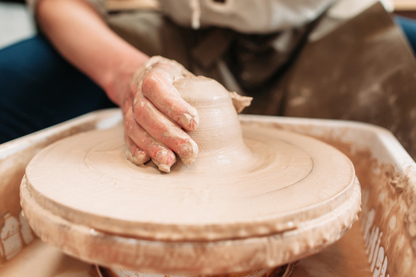 Spinning potters wheel with clay and hand - Valokuva, kuva