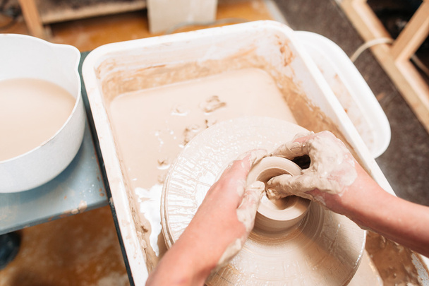 Artist makes pottery bottom on potters wheel - Foto, Imagen