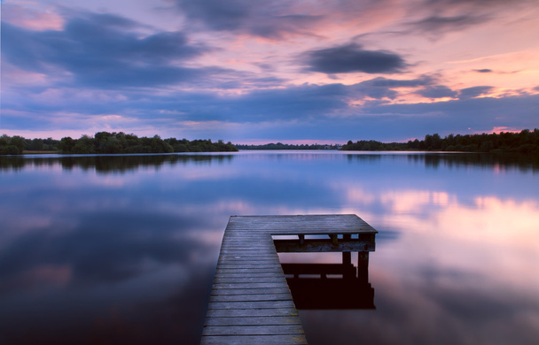 Захід сонця на озері з пірсу
 - Фото, зображення