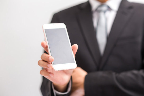 Hombre de negocios mostrar el teléfono celular en traje vestido negro en blanco
  - Foto, Imagen
