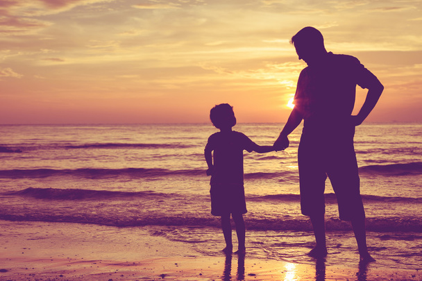 Baba ve oğul sahilde günbatımı anda oynamak. - Fotoğraf, Görsel