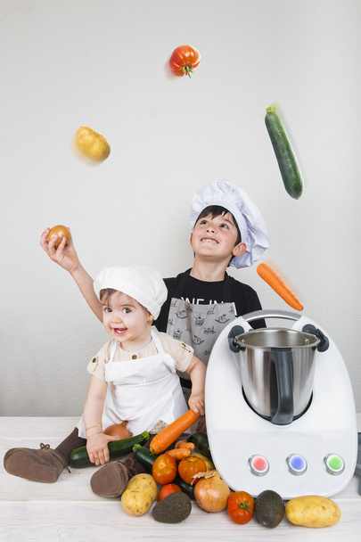 Dos niños cocinando con una máquina futurista
  - Foto, imagen