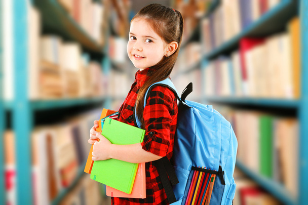 Girl with books in library - Photo, Image