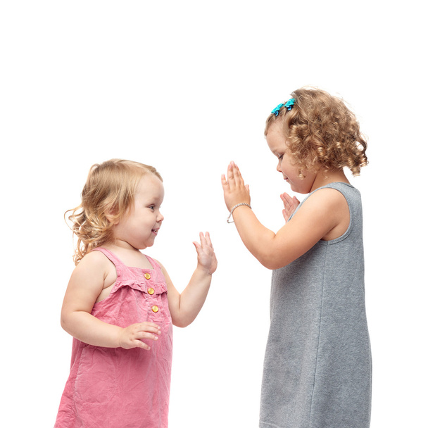 Couple of young little girls standing over isolated white background - Photo, image