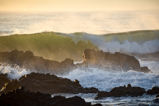 Волны, разбивающиеся о скалы во время прилива океана
 - Фото, изображение