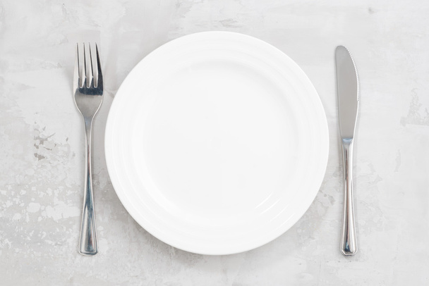 concept photo. White empty plate and cutlery, top view - Zdjęcie, obraz