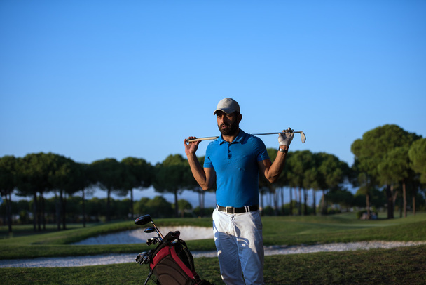 Портрет гольфиста на поле для гольфа на закате
 - Фото, изображение