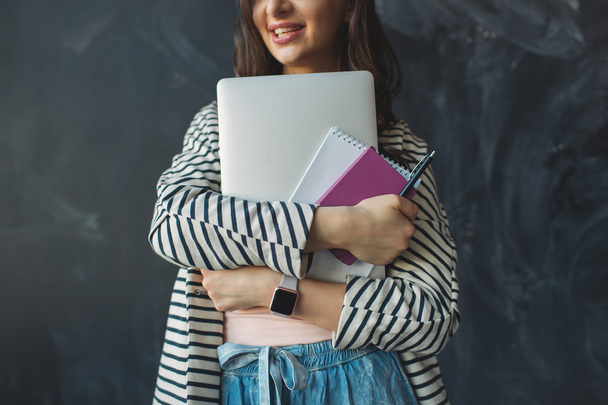 Giovane bella donna con laptop e note in mano sorridenti
 - Foto, immagini