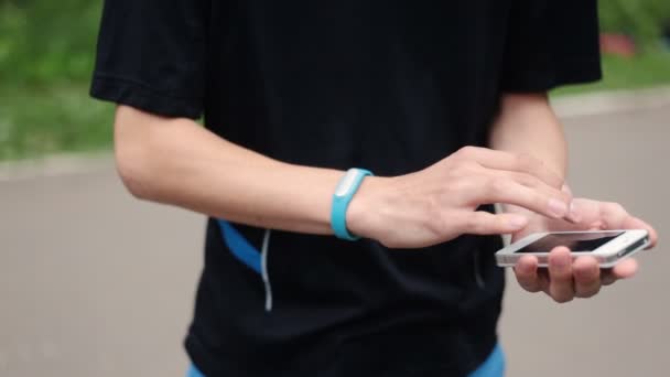 Hombre deportista comprueba su estado físico en un teléfono inteligente
 - Metraje, vídeo