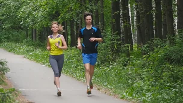 Gelukkige paar joggen in het park, slow-motion - Video