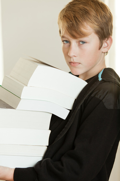 Niño con capucha negra sudadera sosteniendo libros
 - Foto, imagen