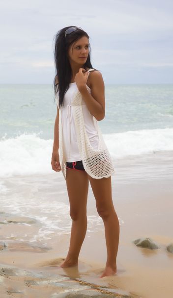 Slim brunette on a beach in a white dress - Фото, зображення