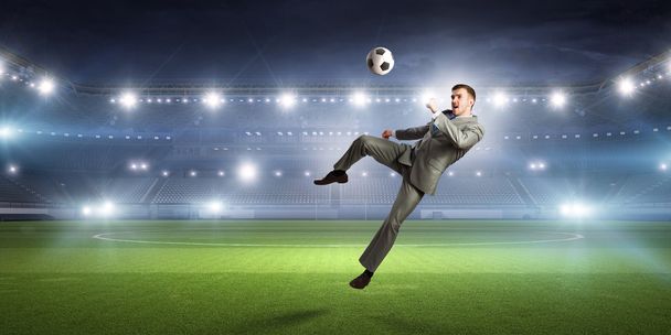 Businessman kicking ball - Foto, imagen