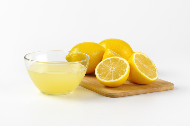 lemon juice and fresh lemons - Foto, afbeelding