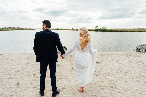 Νύφη και γαμπρός περπάτημα στον ποταμό - Φωτογραφία, εικόνα