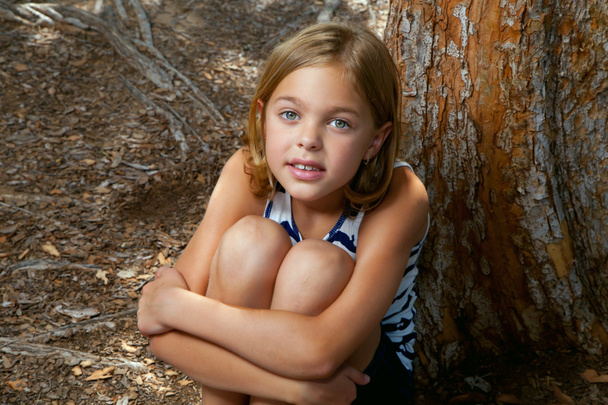 jovem menina senta-se enquanto abraçando pernas
 - Foto, Imagem