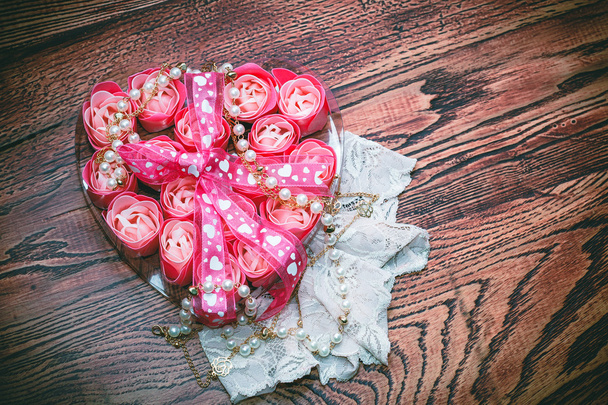 Herz mit Rosen und Schleife auf dem Holzgrund - Foto, Bild