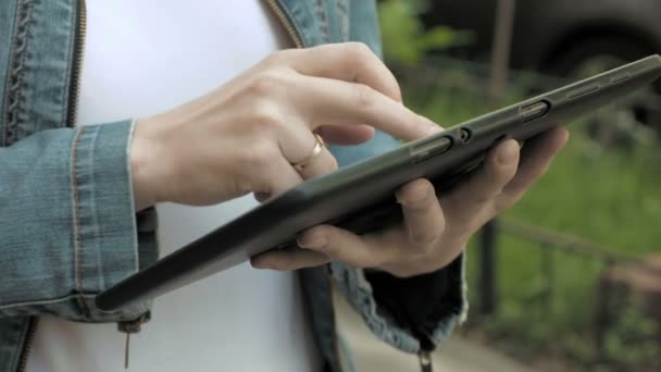 Mujer escribe textos en tableta PC caminando al aire libre
 - Metraje, vídeo