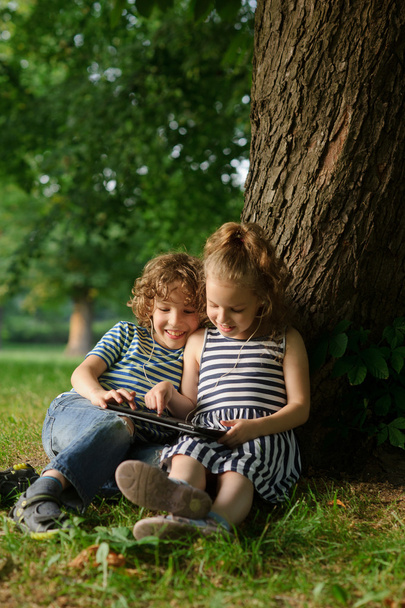 Fratello e sorella di 8-9 anni giocano con passione sul tablet
. - Foto, immagini