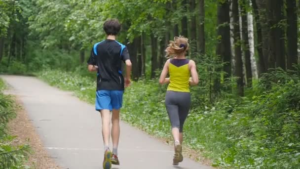 Szczęśliwa para joggingu w parku, w zwolnionym tempie - Materiał filmowy, wideo