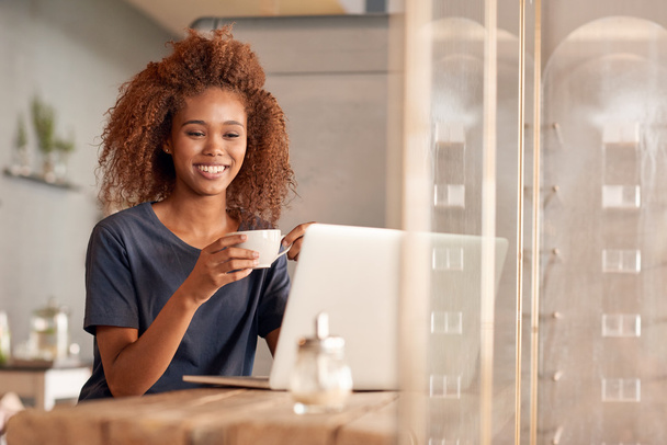 woman working on laptop and drinking coffee - Фото, зображення