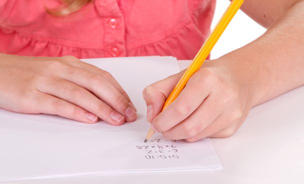 Close-up of a girl doing math problems - Фото, изображение