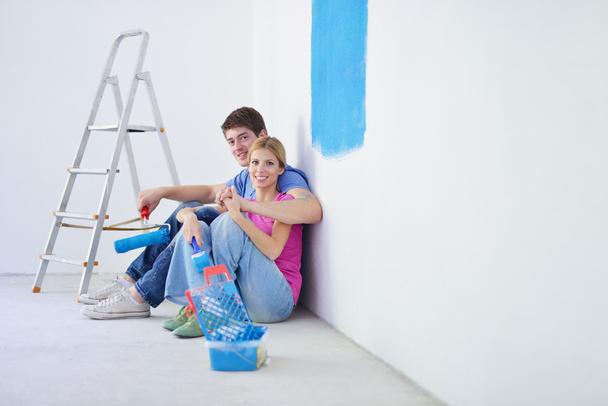 Happy young cople relaxing after painting in new home - Фото, зображення