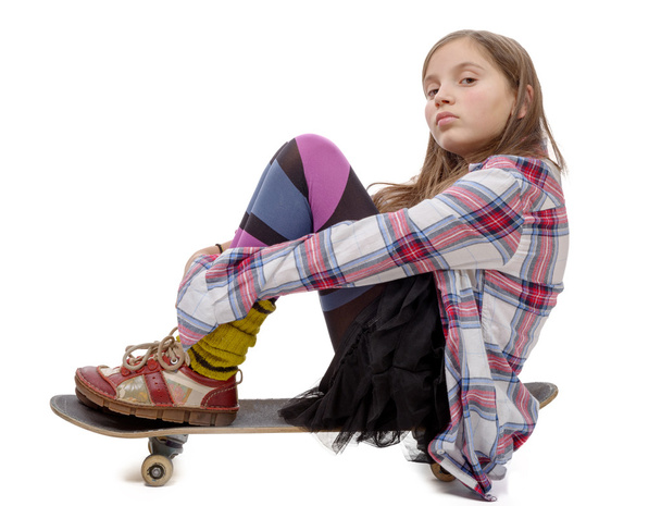 όμορφη νεαρή κοπέλα κάθεται στο skate, σε λευκό - Φωτογραφία, εικόνα