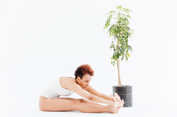 Pacified african american young woman stretching and practicing yoga - Фото, зображення