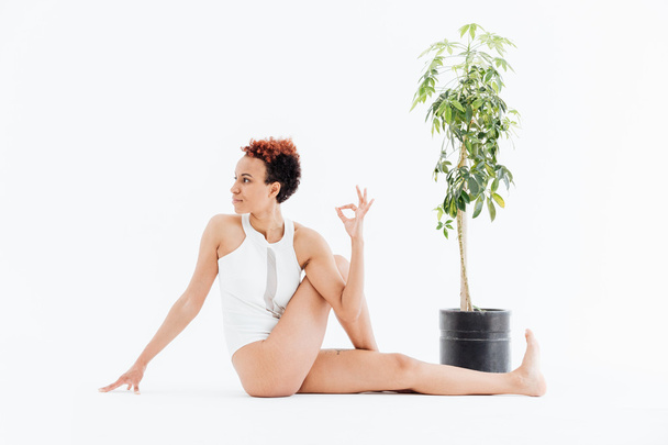 Pretty african american young woman relaxing and practicing yoga - 写真・画像