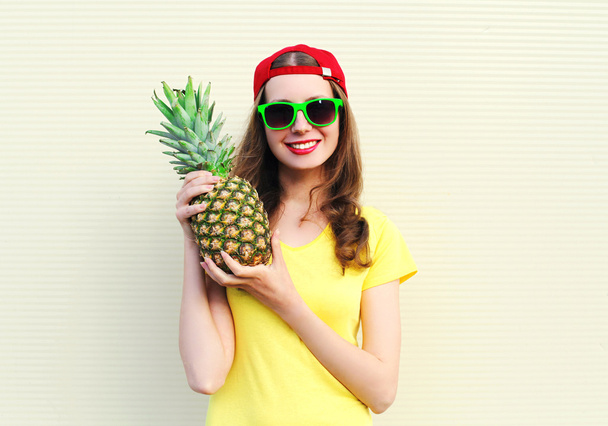 Fashion pretty smiling girl with pineapple over white background - Foto, imagen