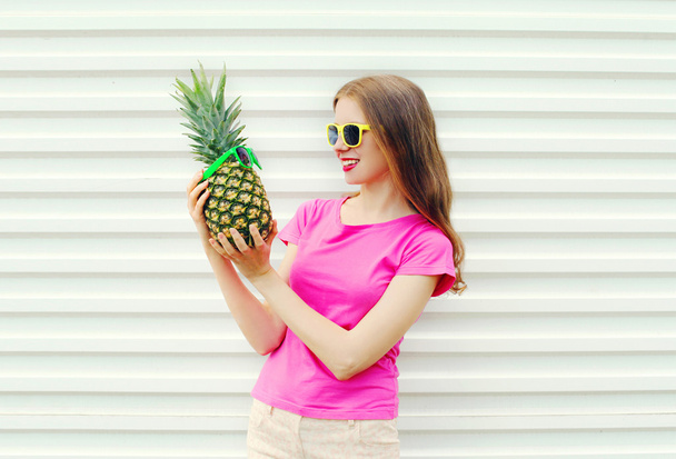 Fashion pretty smiling girl in sunglasses looking on pineapple o - Foto, Bild
