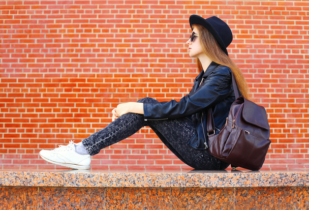Fashion pretty woman in black rock style sitting over bricks bac - Fotó, kép