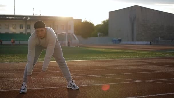 Isınma önce egzersiz yapıyor ve koşu genç atletik erkek - Video, Çekim