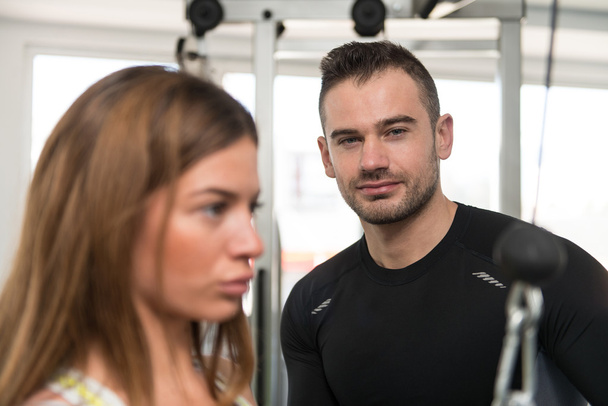 persoonlijke trainer helpen client in gym - Foto, afbeelding