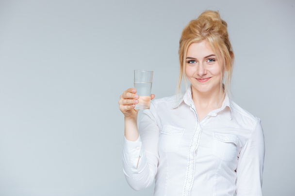 Happy lovely young businesswoman holding glass of water - Photo, Image