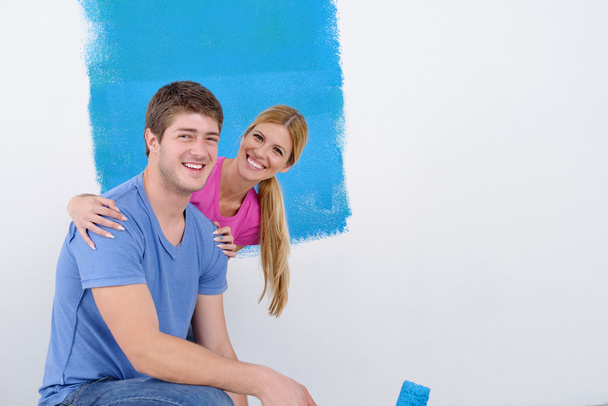 Happy couple paint wall at new home - Zdjęcie, obraz
