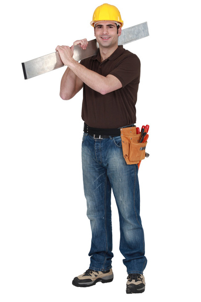 Builder carrying sheet of metal - Photo, image