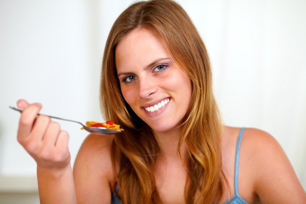 Beautiful blonde girl smiling and eating - Zdjęcie, obraz