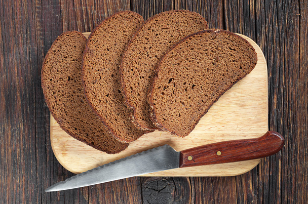 Zwart brood en een mes  - Foto, afbeelding