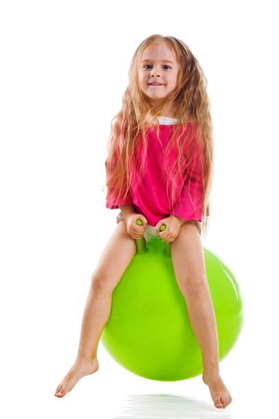 Little girl jump on a big green ball - Fotografie, Obrázek