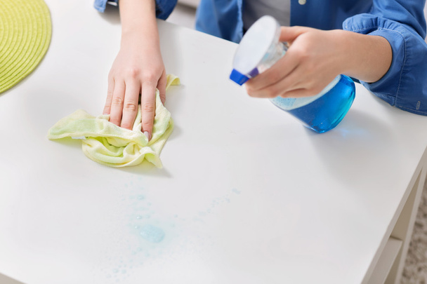 Young woman cleaning the table with a cloth - Photo, Image